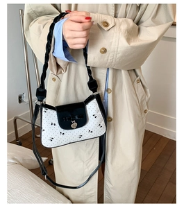 Détail du sac papillon à pois avec pendentif cœur et bandoulière tressée