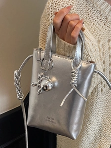 Mini silver metallic bucket bag with cross body strap and decorative dog charm accessory