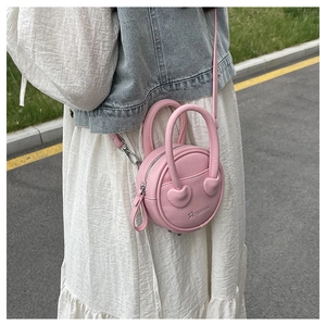 Detail of pink round handbag with heart-shaped stitching and fashion bag embossing