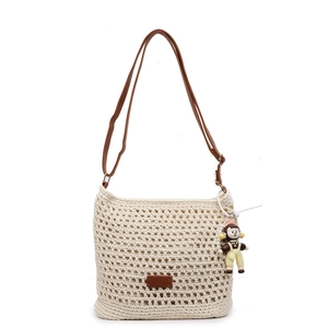Handmade hollow woven beige straw tote bag with brown leather straps and doll pendant