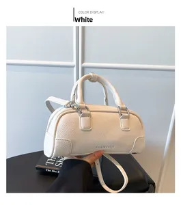 Détail de la texture cuir litchi blanc et fermeture éclair argentée du petit sac boston