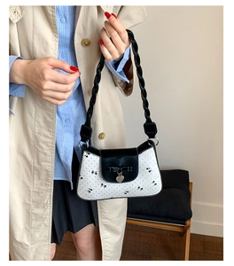 Vue détaillée d'un sac à nœud papillon noir et blanc avec pendentif en forme de cœur