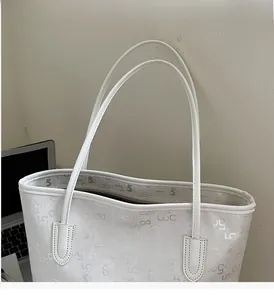 Détail du sac cabas blanc avec motifs de lettres embossés et fines anses en cuir
