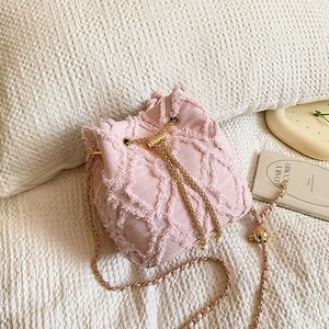 Pink denim bucket bag with frayed quilted pattern and pearl charm strap detail