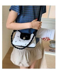 Détail de la poignée en corde noire et du pendentif cœur sur le sac à bandoulière papillon