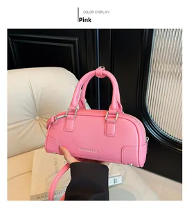 Détail du sac Boston en cuir rose grainé avec des boucles en argent et texte de mode