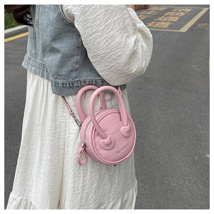 Detail of pink mini round bag showing lychee grain texture and fashion star logo