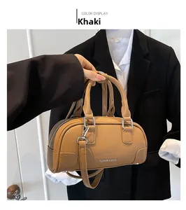 Vue détaillée du mini sac Boston en cuir grainé kaki tenu à la main pour un style chic