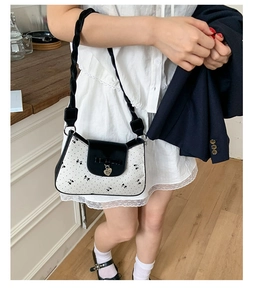 Vue détaillée du sac bandoulière papillon à pois avec pendentif cœur et sangle tissée