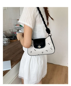 Détail du sac à bandoulière français à pois avec nœud 3D et pendentif cœur élégant