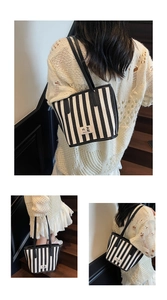 Detail shot of black and white striped tote bag showing durable canvas and branded logo