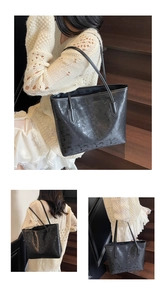 Détail d'un grand sac cabas noir avec lettres imprimées présenté sur un escalier