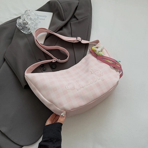 Détail du sac croissant à carreaux roses avec broderie et bandoulière à pompons