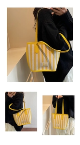 Close-up of yellow and white striped shoulder bag with leather straps and patch detail