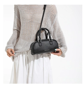 Détail du petit sac noir en cuir grainé avec finitions métalliques argentées