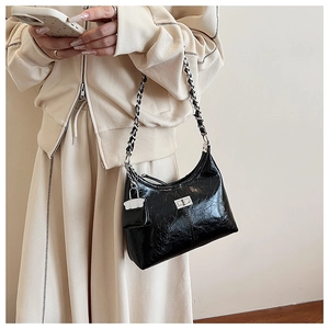 Détail du sac hobo en PU noir plissé avec chaîne argentée et mini pendentif porte-monnaie