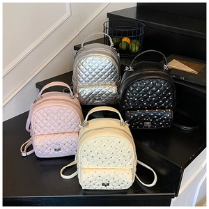 Detailed display of mini quilted backpacks in pink, silver, black and beige colors