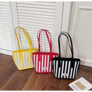 Detailed close-up of colorful striped canvas tote bags in red, yellow and black
