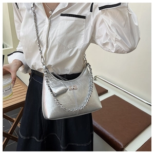 Détail du sac bandoulière argenté en demi-lune avec chaîne métallique et mini pochette
