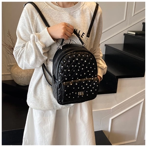 Detail of black quilted leather backpack with sparkling rhinestones and chain straps