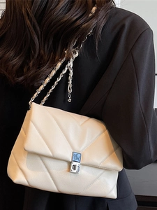 Chic beige quilted crossbody bag with V-shaped stitching and silver metal chain strap
