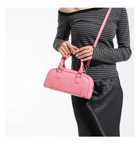 Détail du sac à main rose en cuir grainé avec finitions argentées et bandoulière réglable