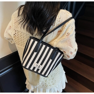 Detailed back view of a minimalist black and white striped tote bag with DAXI label