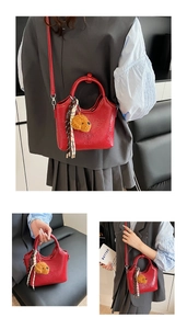 Details der roten Eimer-Tasche aus Wachsleder mit Teddybär-Anhänger und Seidenschal