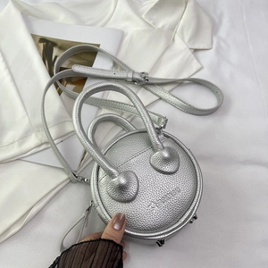 Detail view of silver round crossbody bag with litchi texture and metal studs