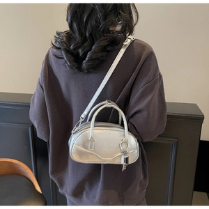Detailed back view of a silver metallic bowling bag with crossbody strap and lock charm