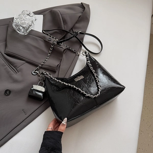 Détail du sac bandoulière noir en cuir froissé avec chaîne argentée et mini pochette