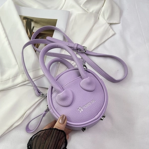Detail view of lavender mini round bag with lychee texture and metallic protective studs