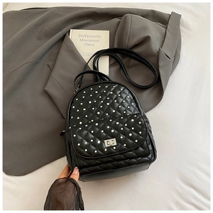 Detail of black quilted mini backpack with silver studs and metal twist lock