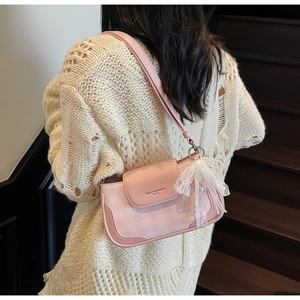 Details der rosa karierten Schultertasche mit Spitzenschleife und Perle am Modell