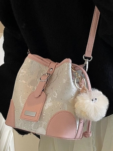Pink and silver marble bucket bag with plush charm shown on a stylish model