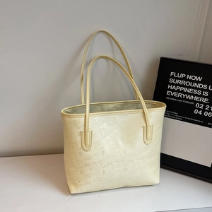 Détail du sac cabas jaune clair avec chiffres embossés sur surface texturée