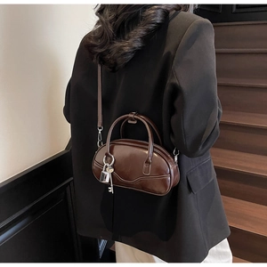 Close-up of vintage dark brown bowling bag with glossy leather finish and silver lock charm