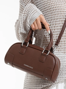 Sac à main marron en cuir grainé avec inscription blanche et détails argentés sur pull blanc