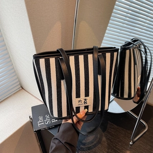 Detail showing vertical black and white stripes and textured fabric of the large tote bag
