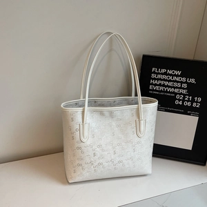 Gros plan du sac cabas en cuir blanc avec motifs numériques gris et longues anses fines