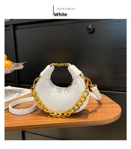 Détail d'un sac hobo blanc en cuir grainé avec une chaîne dorée et bandoulière fine