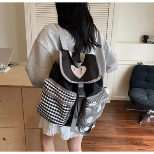 Detail of cute mini backpack with heart patch and mixed pattern contrast pockets