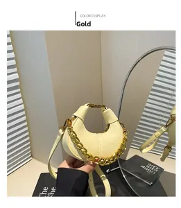 Détail d'un sac à main jaune clair en cuir grainé avec une chaîne dorée et une bandoulière