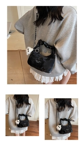 Detail of black velvet cloud bag with metal chain strap and cute bear plush pendant