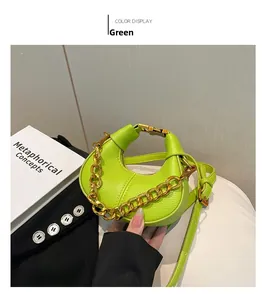 Détail du sac croissant vert néon avec cuir texturé et bandoulière chaîne dorée