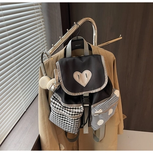 Detailed close-up of fashion backpack with heart pattern and checkered side pocket