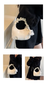 Detail of white pleated cloud bag with silver chain strap and monster plush charm