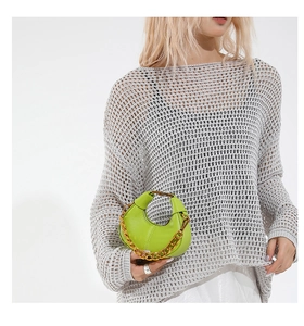 Détail du sac à chaîne en cuir vert citron avec poignée dorée et texture grainée