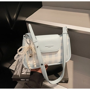 Detailansicht der hellblauen karierten Handtasche mit Perlenkette und weißer Schleife