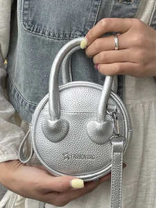 Silver round mini crossbody bag in lychee leather with heart-shaped handle details